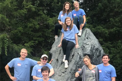 Students posing on a rock