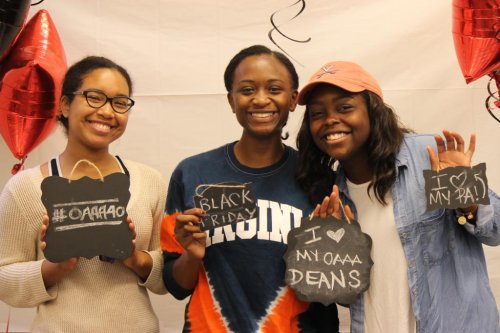 Three students holding signs