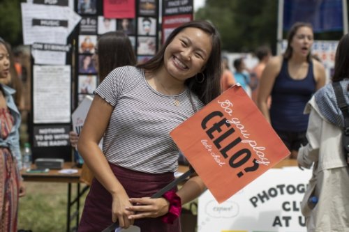 Student with a sign at the Activities fair