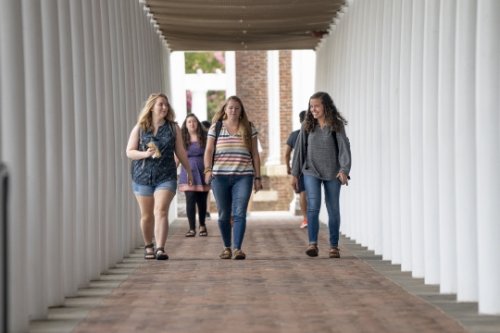 Students walking under columns
