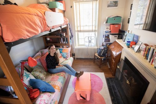 Student sitting on lower bunk in dorm room